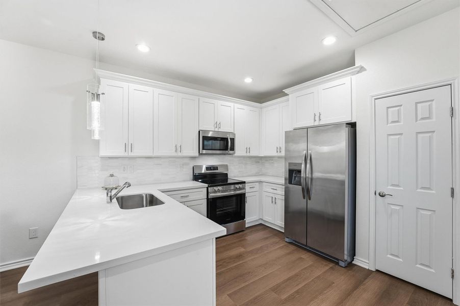 Stainless steel appliances, tile backsplash, and a large pantry complete the kitchen, making it equally appealing for personal use or rental guests.