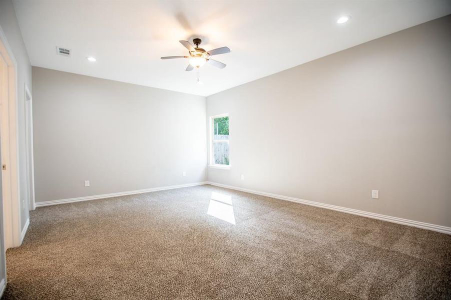 Carpeted spare room featuring ceiling fan