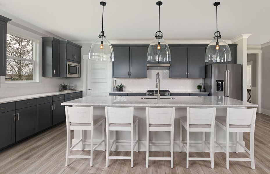 Gourmet Kitchen with decorative lighting with grey cabinets and a bright white island.