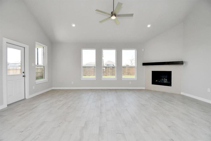 Relax and unwind in this inviting family room, illuminated by abundant natural light streaming in through tall windows, complemented by high ceilings and stunning flooring. Stay comfortable year-round with the gentle breeze from the ceiling fan, creating the perfect atmosphere for family gatherings.