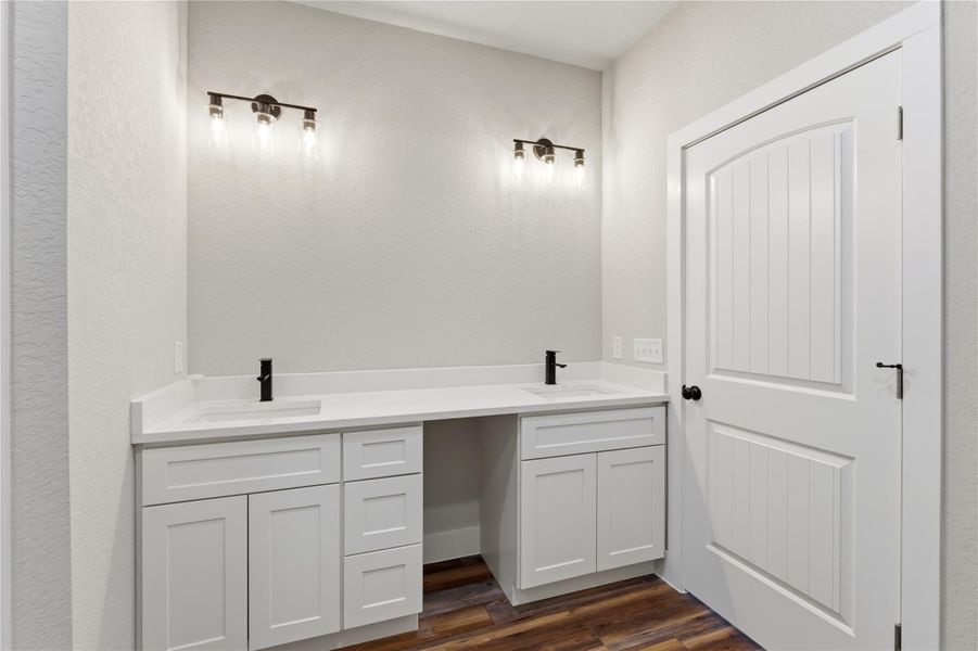 Bathroom featuring vanity, dark wood-type flooring, and a textured wall