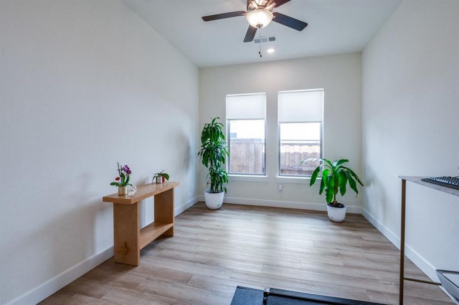 Living area featuring light wood finished floors and ceiling fan Living area featuring light wood finished floors and ceiling fan