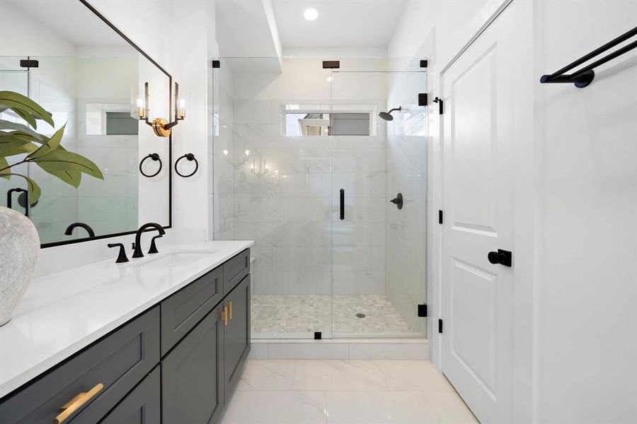 Luxurious primary bathroom with elegant fixtures, a spacious glass-enclosed shower, and stylish double vanity.