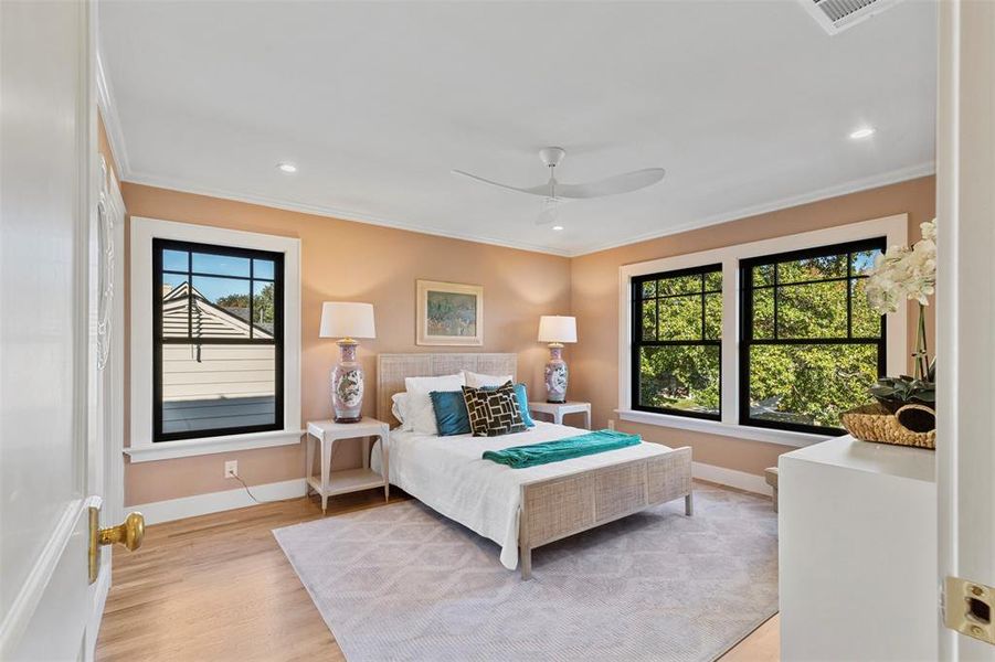 Bedroom featuring ceiling fan, crown molding, and light wood-type flooring