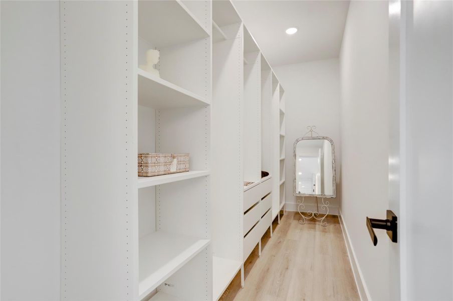 The spacious primary closet has custom built-in shelves and drawers. The spacious primary closet has custom built-in shelves and drawers.