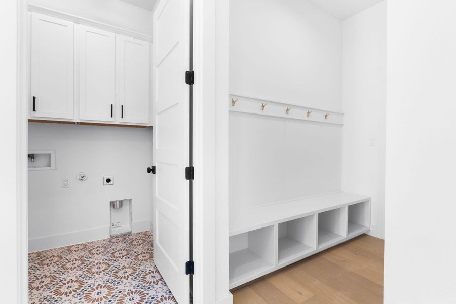 Laundry room featuring hookup for washer/dryer, cabinet space, washer hookup, patterned tile underfoot Laundry room featuring hookup for washer/dryer, cabinet space, washer hookup, patterned tile underfoot