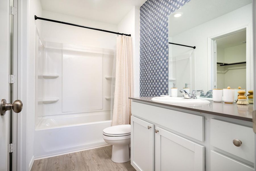 Full bath with vanity, wood finished floors, and shower / bath combination with curtain Full bath with vanity, wood finished floors, and shower / bath combination with curtain