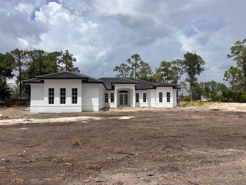 Front exterior of a new home in , The Acreage, FL, highlighting curb appeal (Image 1).