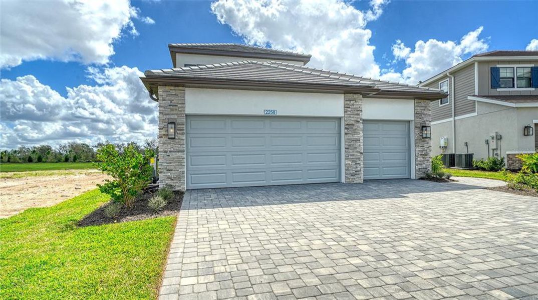 Front exterior of a new home in Palm Grove, Lakewood Ranch, FL, highlighting curb appeal (Image 21).