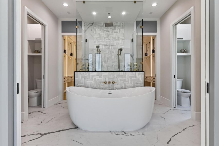Spa-inspired bath with freestanding soaking tub, marble surround, and dual vanity.