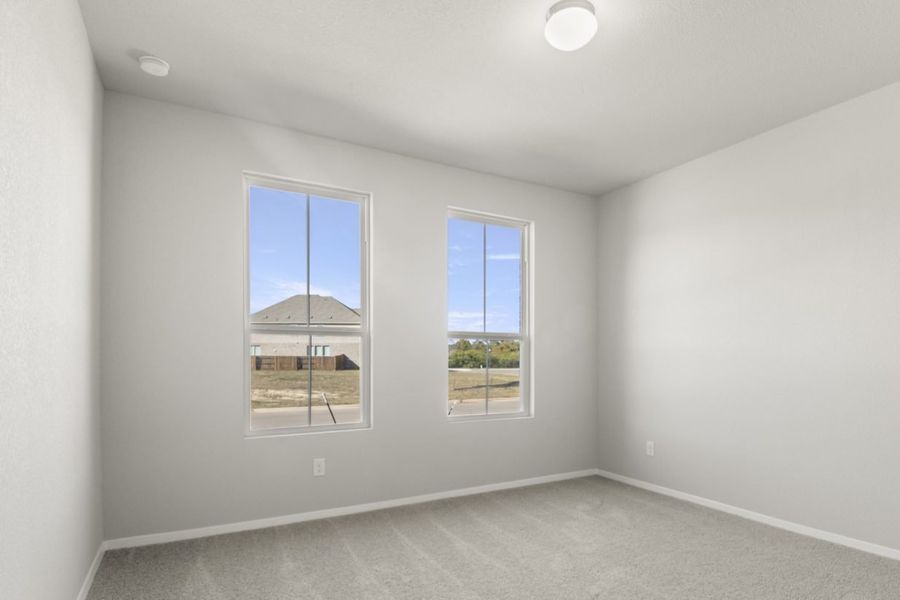 Image of a bedroom with tan carpeting and light grey painted walls with two windows Image of a bedroom with tan carpeting and light grey painted walls with two windows