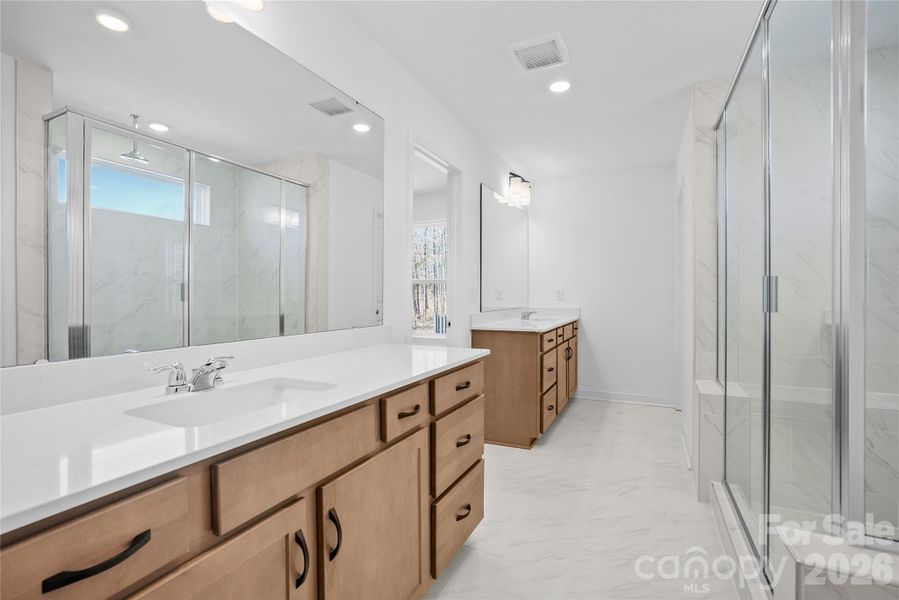 Nicely appointed owner's bath with separate vanities and great storage