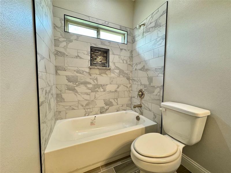 Bathroom featuring toilet and tiled shower / bath