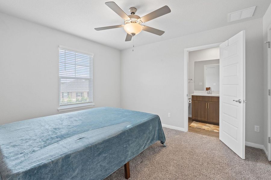 Bedroom featuring light carpet, a sink, visible vents, baseboards, and ceiling fan Bedroom featuring light carpet, a sink, visible vents, baseboards, and ceiling fan