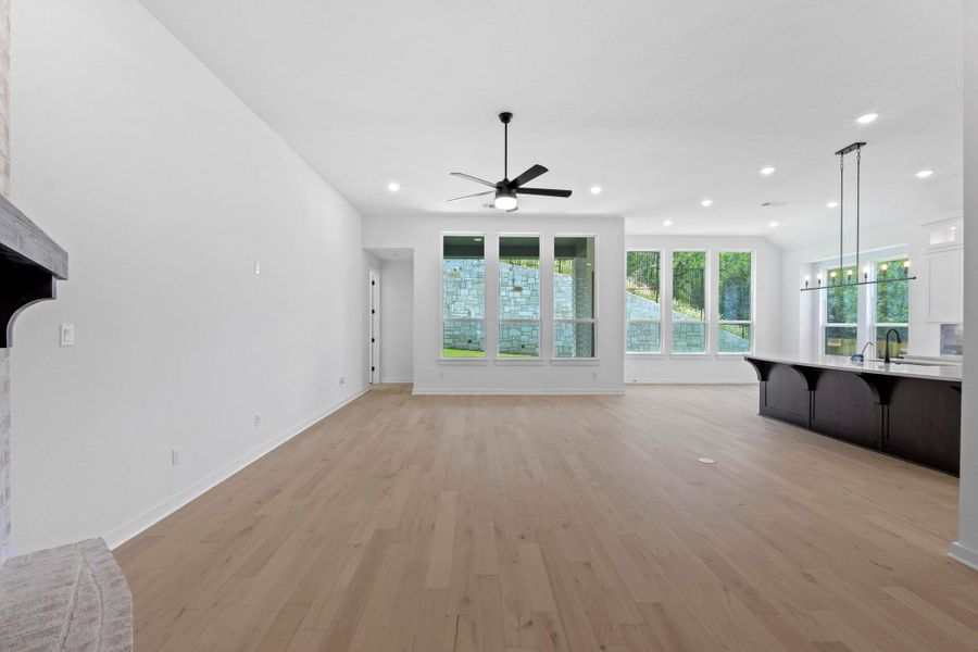 Unfurnished living room with a ceiling fan, plenty of natural light, light wood-style flooring, and recessed lighting