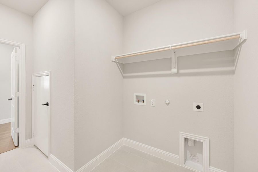 Laundry room with wall-mounted shelf, washer and dryer hookups, and a pet door at floor level.