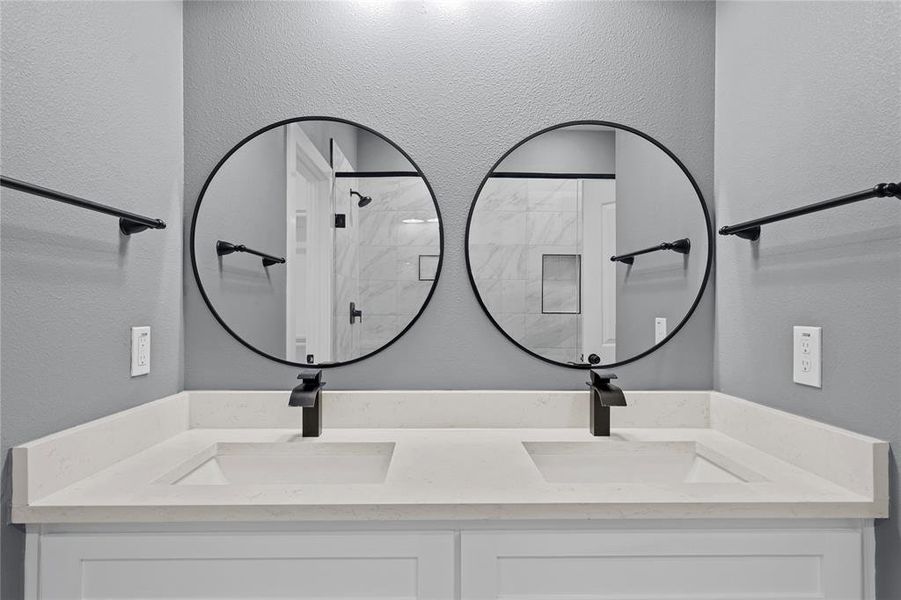 Bathroom with a textured wall, a stall shower, and double vanity Bathroom with a textured wall, a stall shower, and double vanity