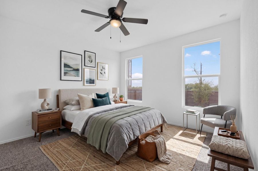 Tall windows frame views of the outdoors in this comfortable bedroom. Tall windows frame views of the outdoors in this comfortable bedroom.