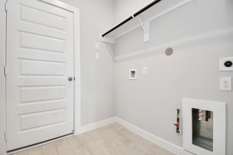A perfect blend of functionality and comfort. Capture the essence of easy living with a first-floor laundry room, thoughtfully equipped with shelving for effortless organization. Both electric and gas connections available. Sample photo of completed home with similar floor plan. Actual colors and selections may vary. A perfect blend of functionality and comfort. Capture the essence of easy living with a first-floor laundry room, thoughtfully equipped with shelving for effortless organization. Both electric and gas connections available. Sample photo of completed home with similar floor plan. Actual colors and selections may vary.