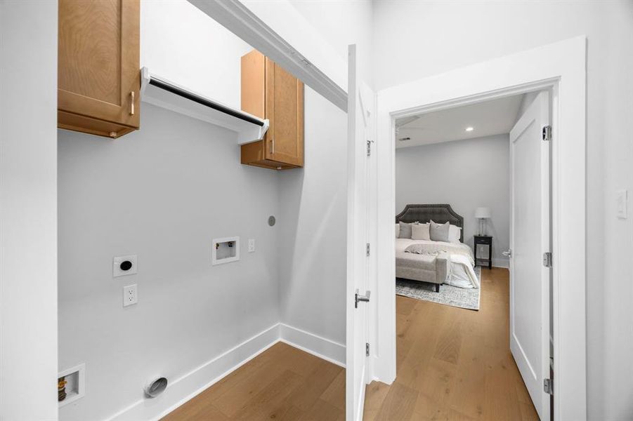 Dedicated laundry area with upper storage cabinets, conveniently located near the bedroom for easy access.