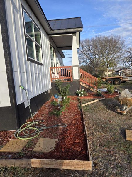 View of side of property with a vegetable garden and a metal roof