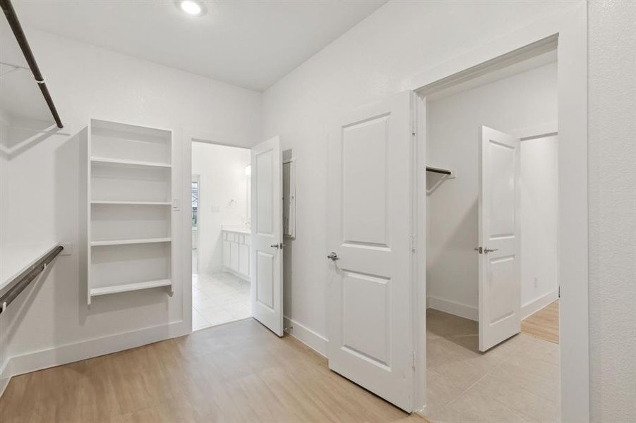Walk in closet featuring light wood finished floors Walk in closet featuring light wood finished floors