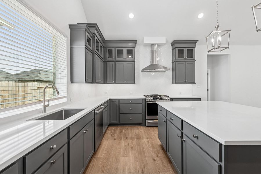 Stunning kitchen with grey stacked cabinets and quartz counters (*Photo not of actual home and used for illustration purposes only.)