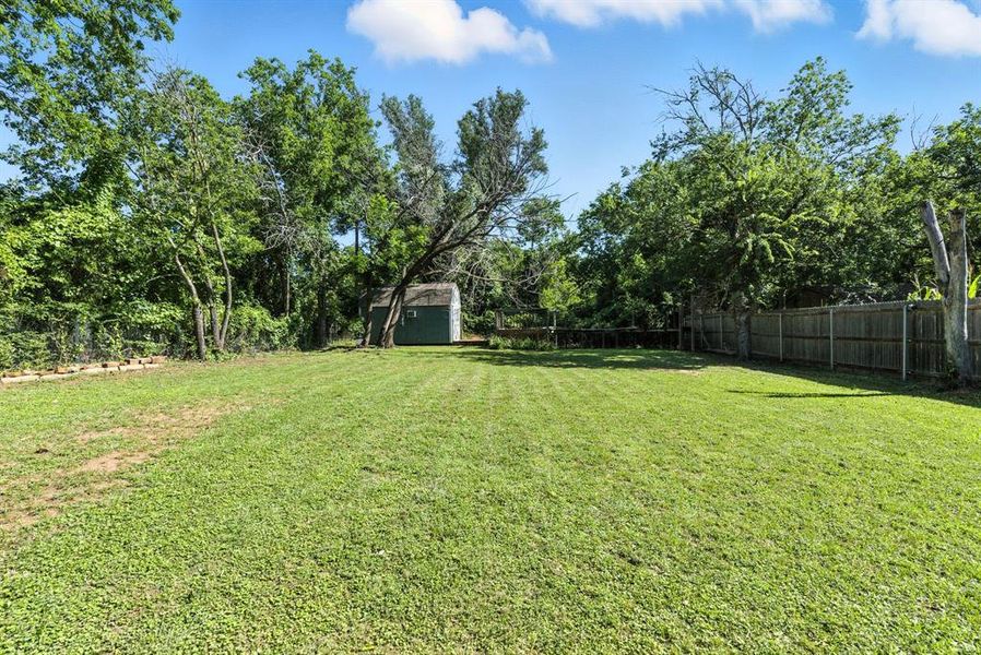 Fenced backyard with a storage shed