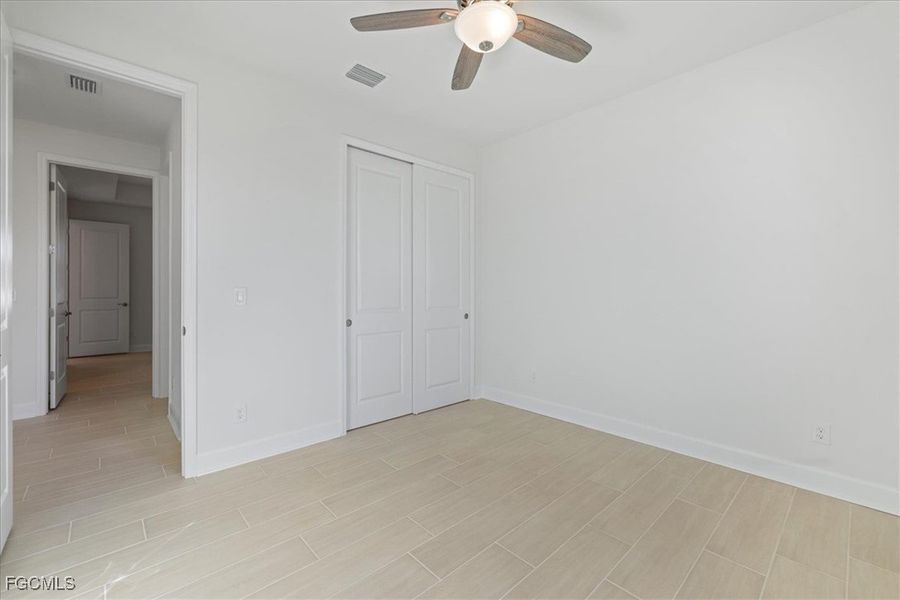 Unfurnished bedroom featuring a closet, ceiling fan, and wood finish floors Unfurnished bedroom featuring a closet, ceiling fan, and wood finish floors