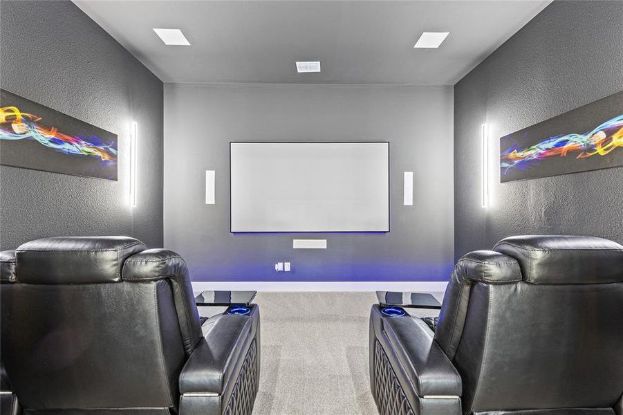 Home theater room featuring a textured wall and carpet floors