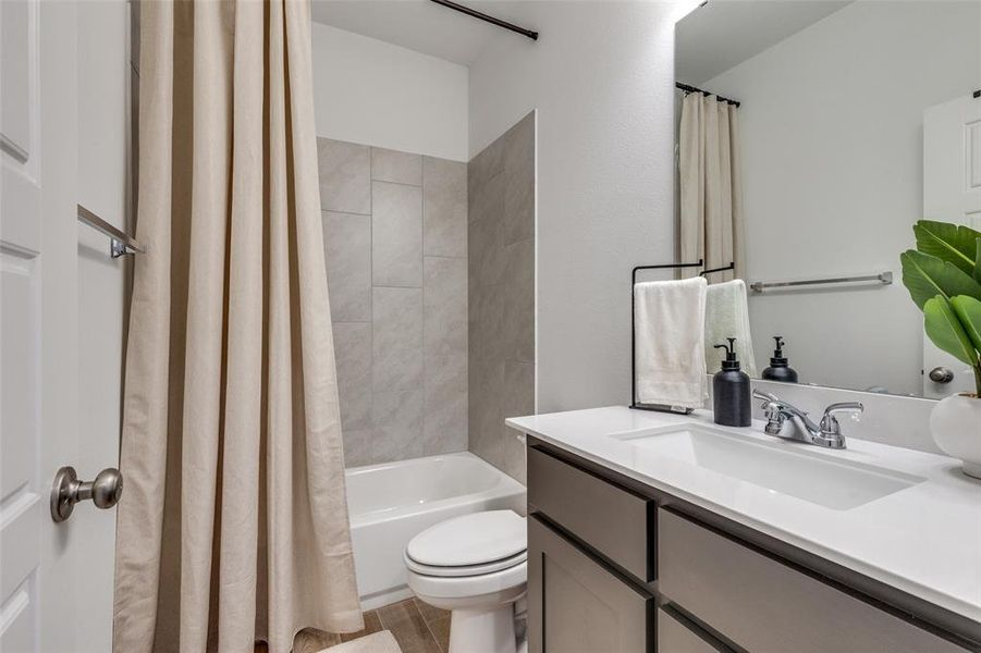 Full bath with shower / bath combination with curtain and vanity