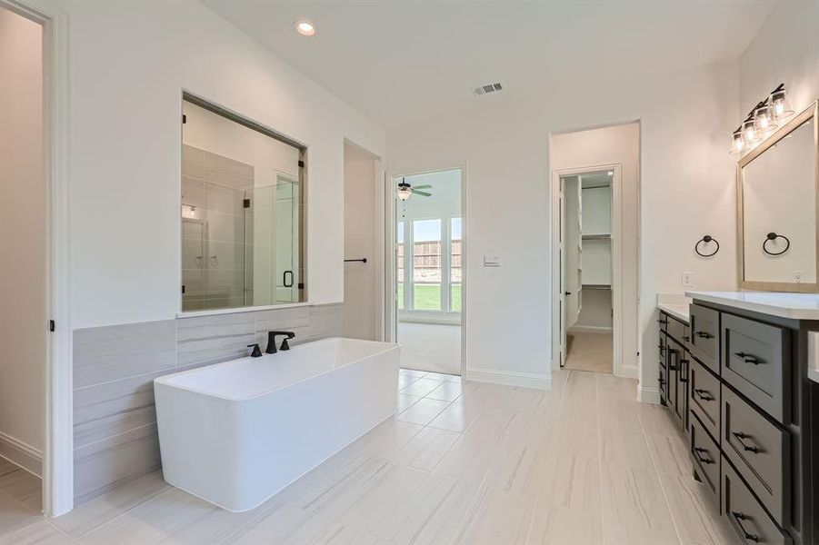 Bathroom with vanity, plus walk in shower, ceiling fan, and tile patterned floors