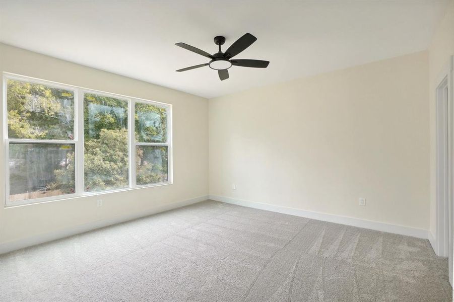 Carpeted spare room featuring ceiling fan