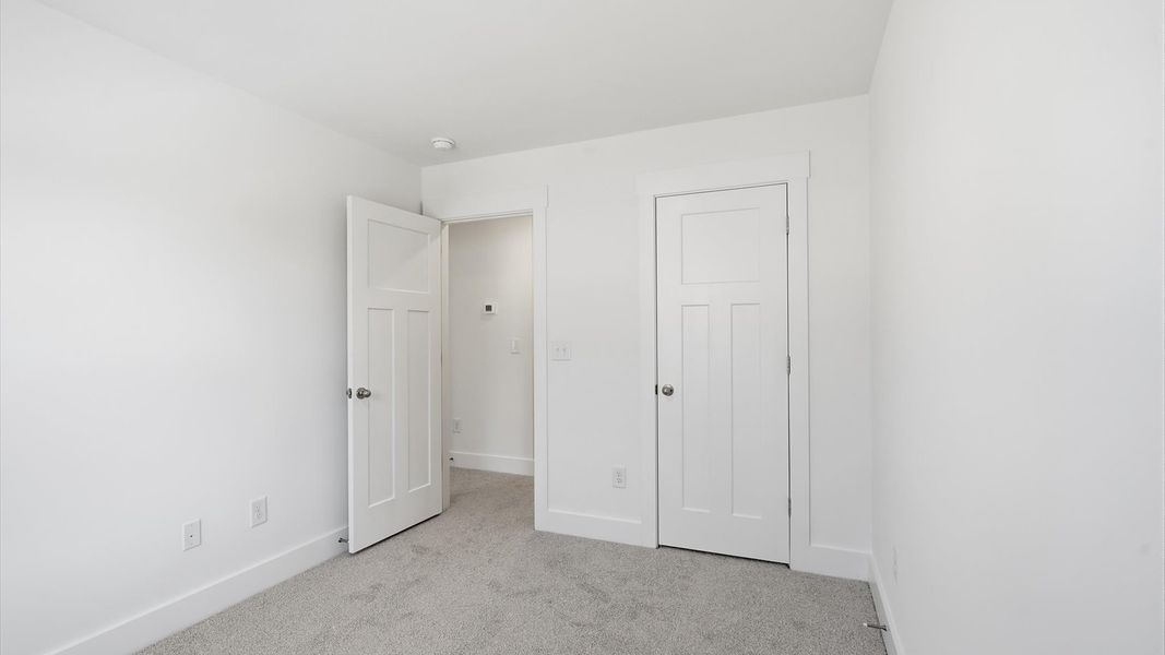 First-class secondary bedroom with comfortable carpeted flooring and generous closet space at Clarke Townes