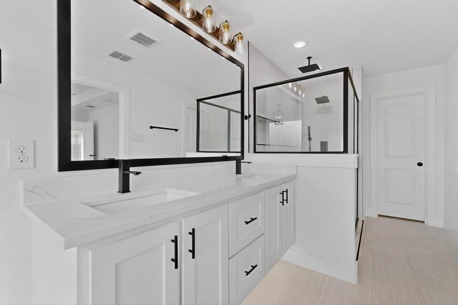 Full bathroom with double vanity, a stall shower, and recessed lighting