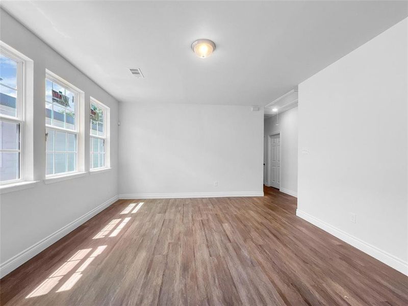 Empty room featuring wood finished floors and baseboards Empty room featuring wood finished floors and baseboards
