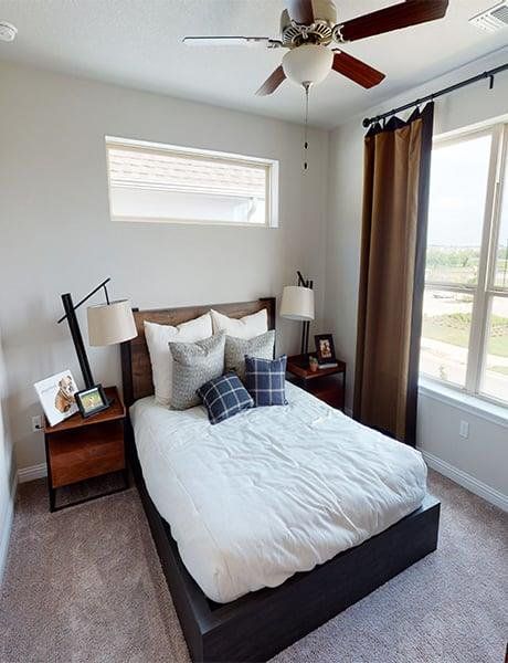 Carpeted bedroom featuring baseboards and ceiling fan