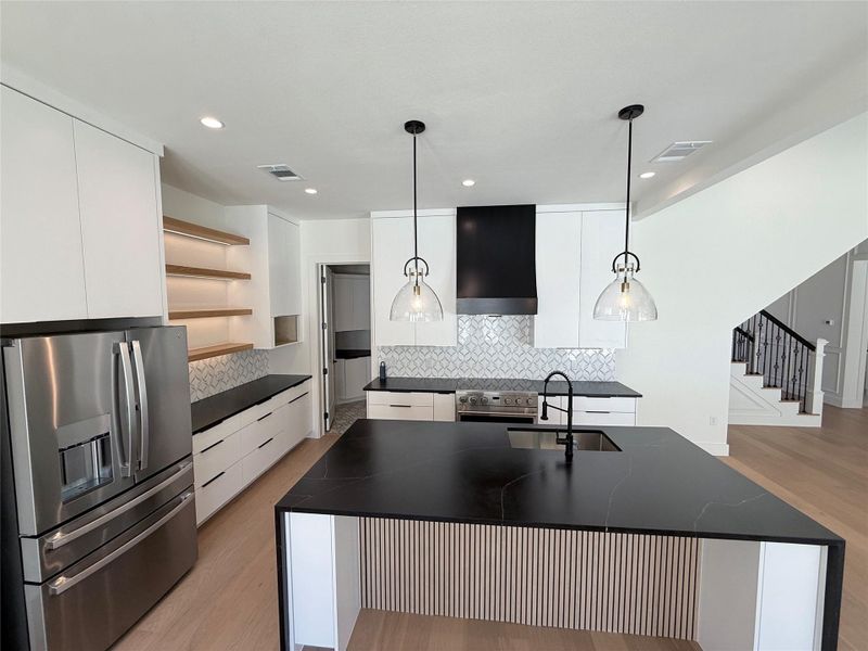 Kitchen with stainless steel appliances, white cabinetry, open shelves, modern cabinets, and light wood-style floors Kitchen with stainless steel appliances, white cabinetry, open shelves, modern cabinets, and light wood-style floors