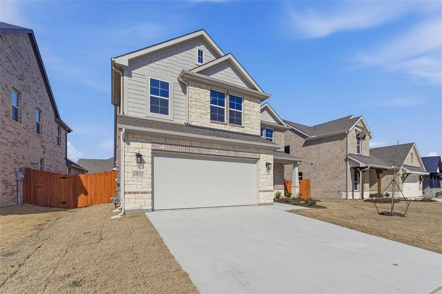 Craftsman-style home featuring stone siding, a garage, a gate, and driveway