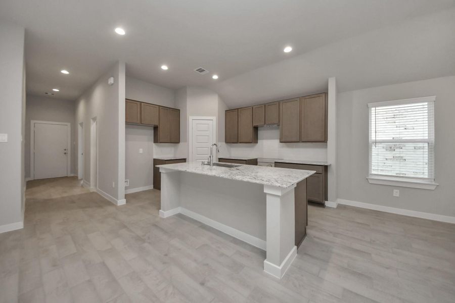 This kitchen is by far any chef’s dream! This spacious kitchen features high ceilings, lightstained wood cabinets, granite countertop, SS appliances, modern tile backsplash,recessed lighting, extended counter space, granite kitchen island with double sink, andspace for breakfast bar, and a walk-in pantry all overlooking your huge family room. Sample photo of completed home with similar floor plan. Actual colors and selections may vary. This kitchen is by far any chef’s dream! This spacious kitchen features high ceilings, lightstained wood cabinets, granite countertop, SS appliances, modern tile backsplash,recessed lighting, extended counter space, granite kitchen island with double sink, andspace for breakfast bar, and a walk-in pantry all overlooking your huge family room. Sample photo of completed home with similar floor plan. Actual colors and selections may vary.