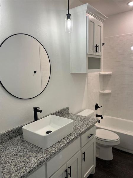 Full bath featuring vanity, shower / bath combination, and dark wood-type flooring