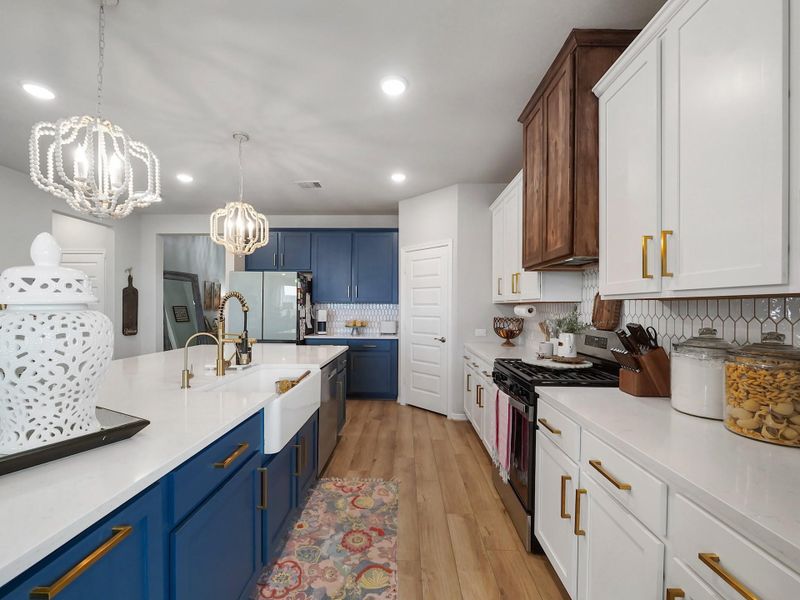 The kitchen has been thoughtfully upgraded with an expansive island more than double its original size, custom cabinetry with added storage and pull-out trash, a farmhouse sink, designer fixtures, and a striking custom vent hood—creating a space that is as functional as it is visually stunning.