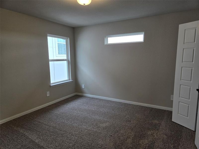 Unfurnished room with dark colored carpet Unfurnished room with dark colored carpet
