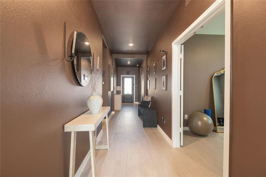 Long hallway featuring light wood-finish flooring and a consistent ceiling height Long hallway featuring light wood-finish flooring and a consistent ceiling height