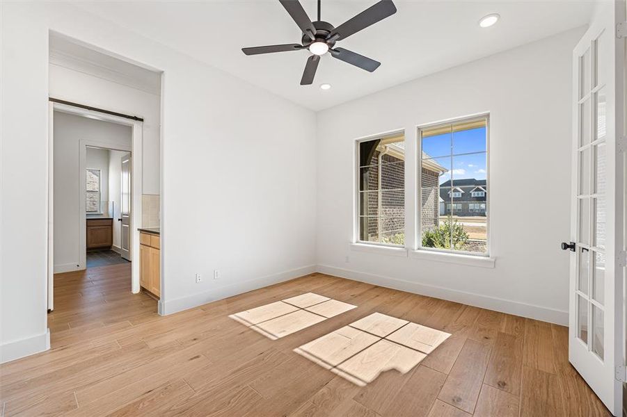 Empty room featuring light wood-style flooring, ceiling fan, and recessed lighting