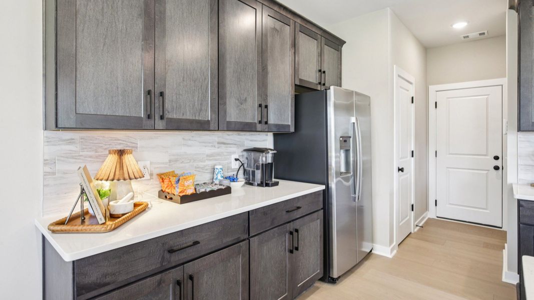 Kitchen with quartz countertops and dark cabinetry