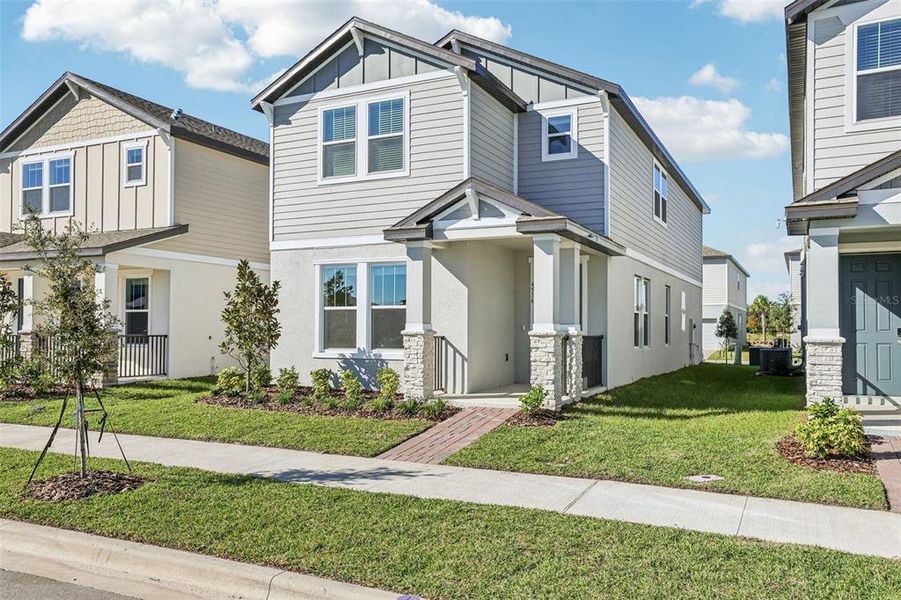 Front exterior of a new home in The Meadow at Crossprairie Bungalows, St. Cloud, FL, highlighting curb appeal (Image 20).