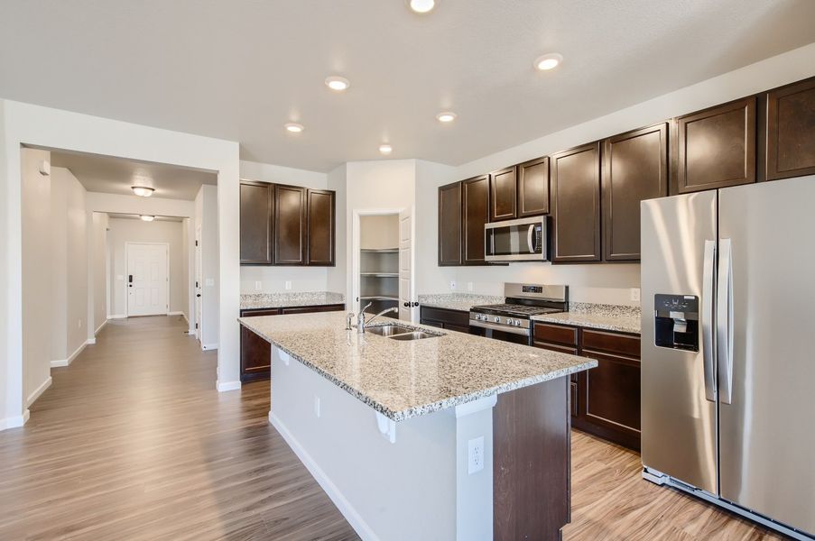 Open concept kitchen and hallway of the ranch style Telluride plan by Century Communities