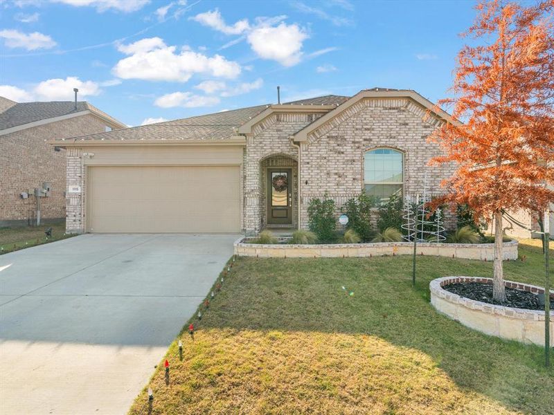 View of front of property featuring a front yard and a garage