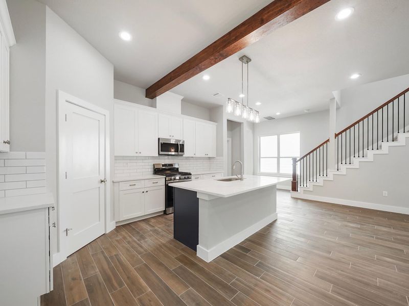 Kitchen is mix of navy blue island and white cabinets